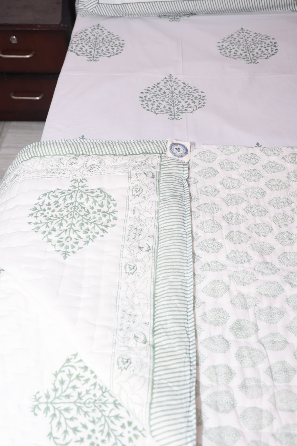 Close-up of grey floral hand block printed quilt showing detailed buta pattern