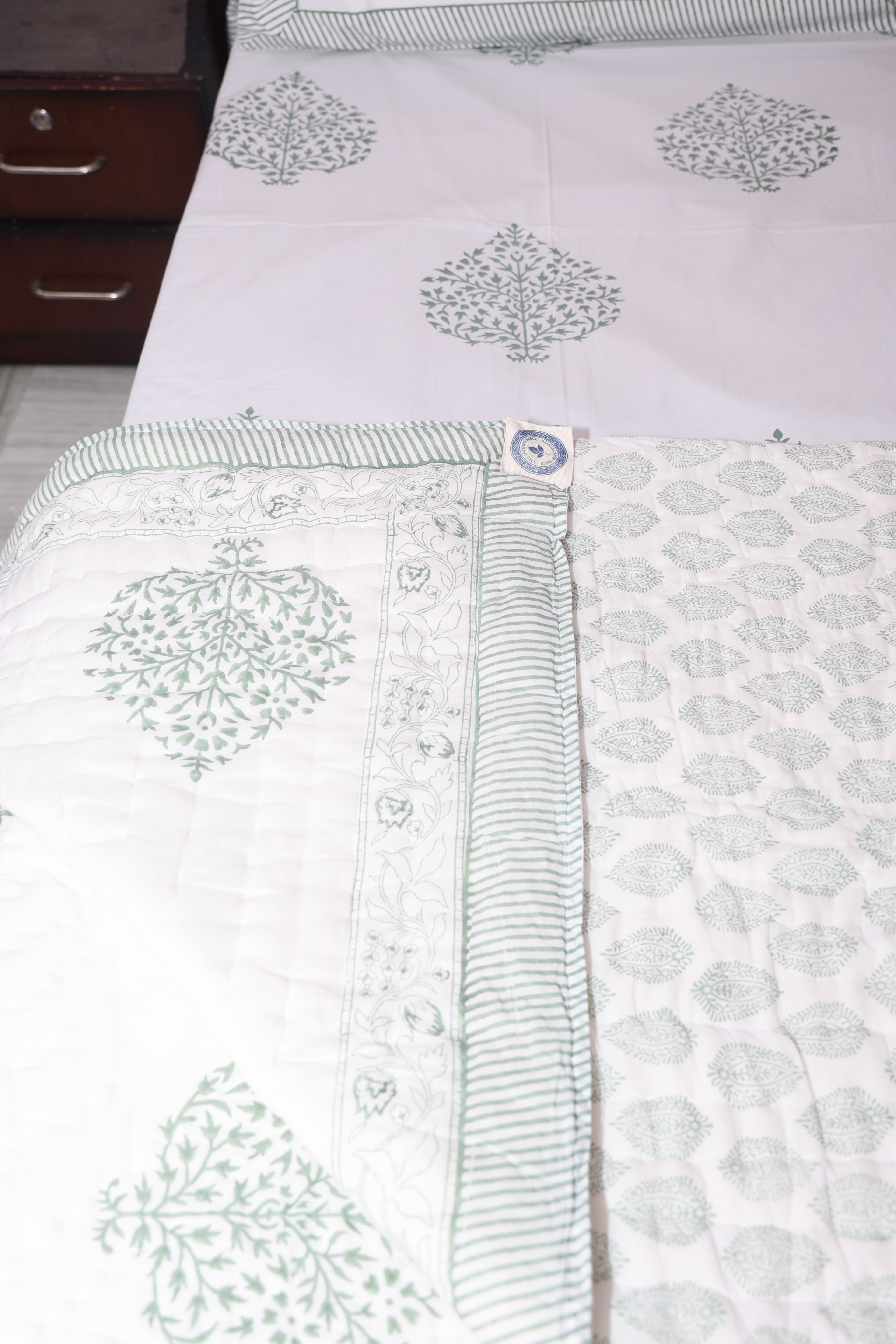 Close-up of grey floral hand block printed quilt showing detailed buta pattern