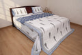 Artisanal indigo blue and white hand block printed cotton bedding set with botanical motifs on bed