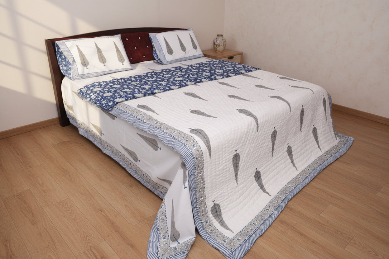 Artisanal indigo blue and white hand block printed cotton bedding set with botanical motifs on bed