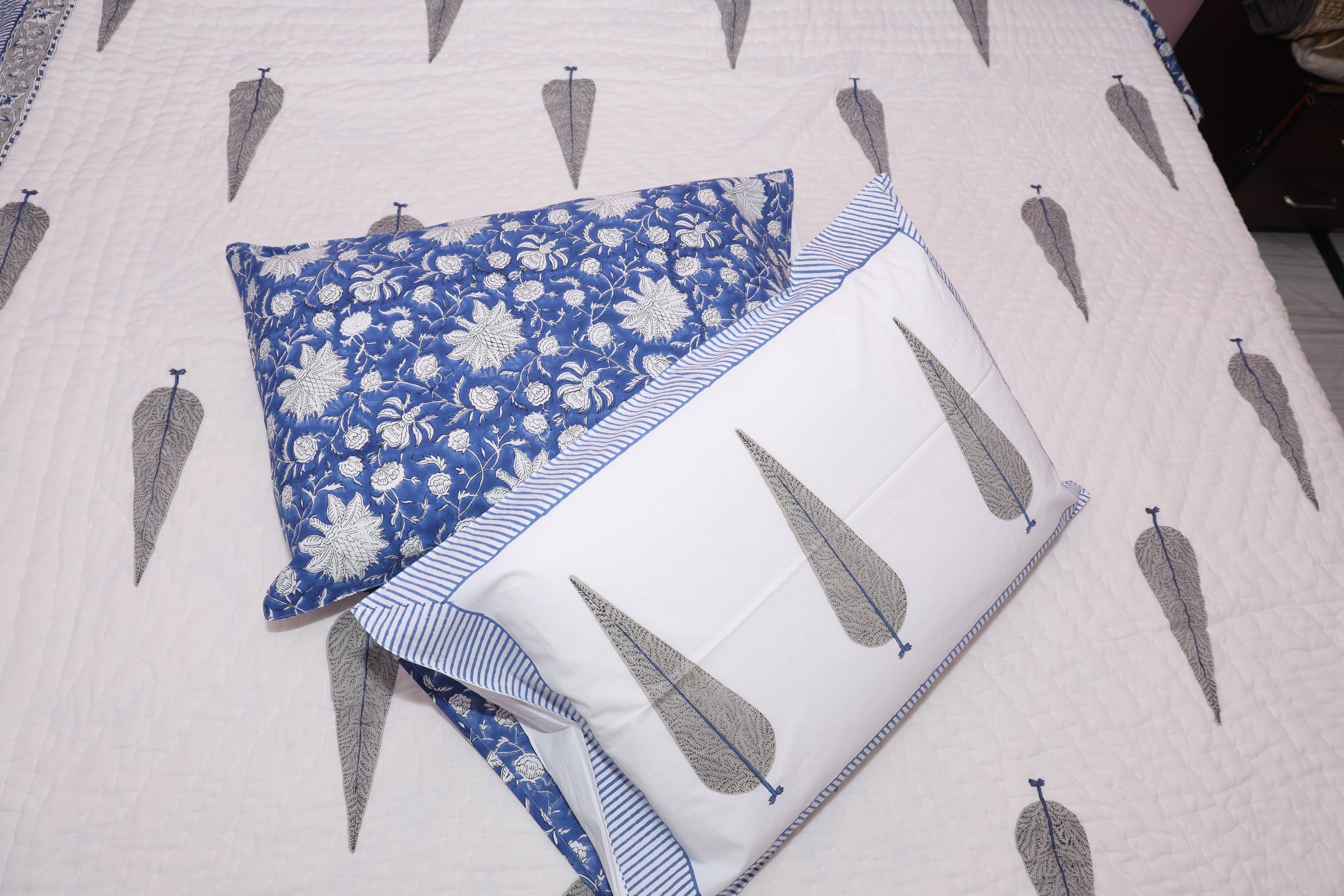 Close-up detail of indigo hand block printed cotton fabric showing artisan botanical pattern