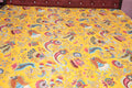 Saffron paisley kantha throw folded on wooden surface showing artisan stitching
