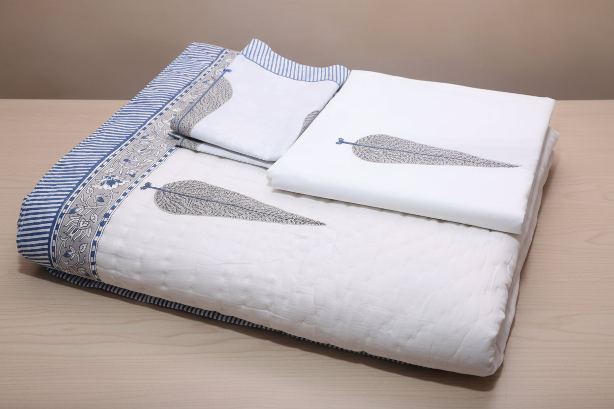 Artisanal indigo bedding set styled on bed showing pillow covers and quilt ensemble