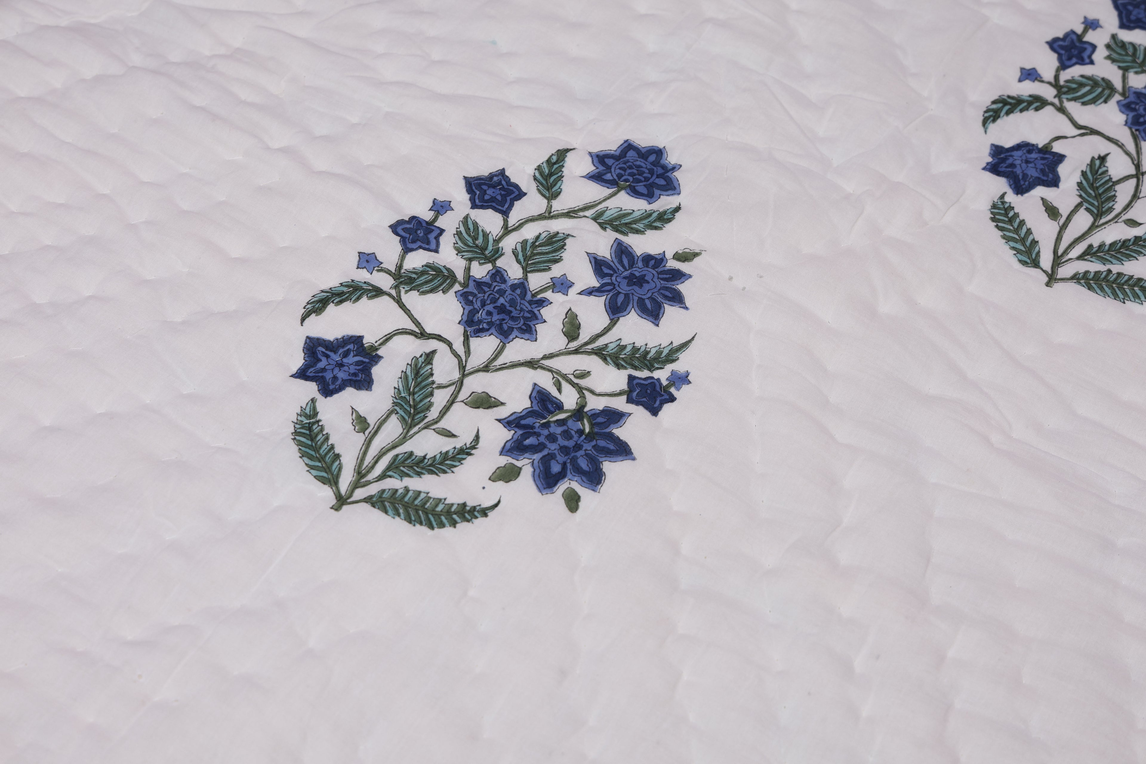  blue flowers on a white fabric background