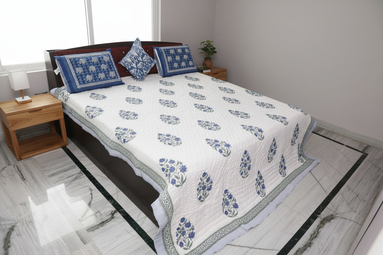 Bed with floral patterned quilt and pillows in a room 
