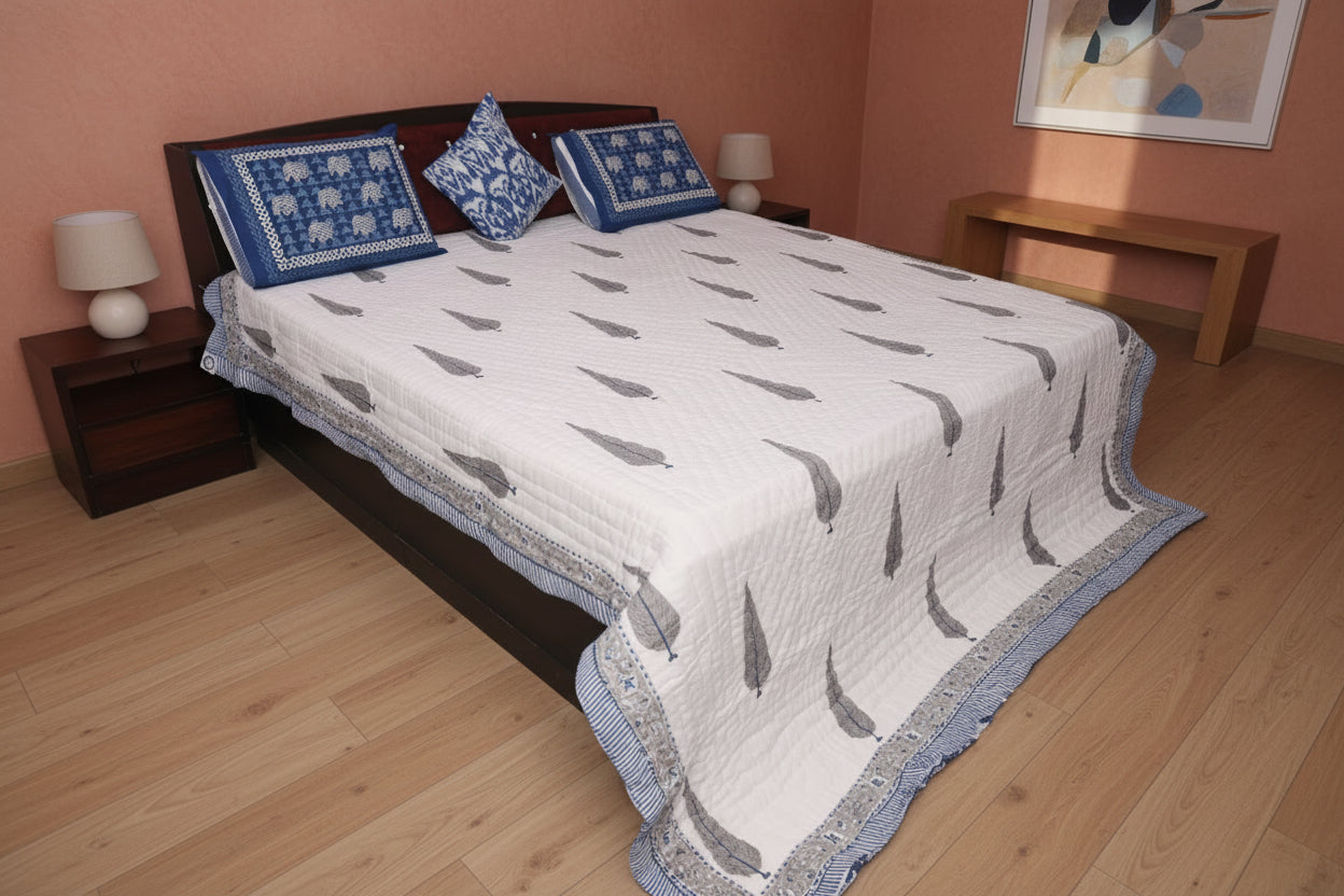 Bed with a white quilt and blue pillows in a bedroom setting.