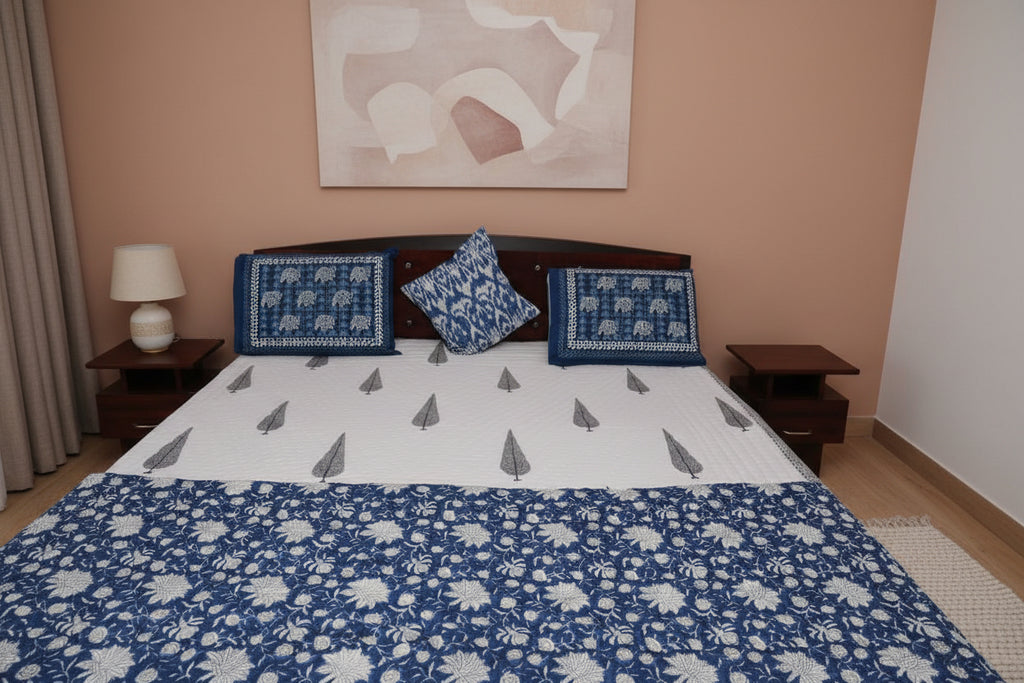 Bed with blue and white floral patterns on a quilt 