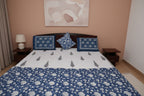 Bed with blue and white floral patterns on a quilt 