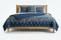 Detail of gilded indigo quilt turned back showing reversible print and cotton fill